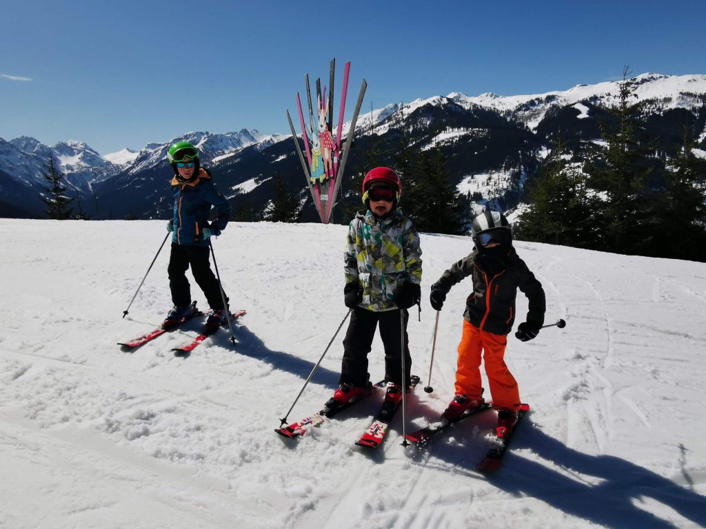 Spaß auf der Piste: Drei Kinder beim Skifahren in Kleinarl – der Bio-Bauernhof Schwabhof ist der ideale Ausgangspunkt für kleine Pistenflitzer.