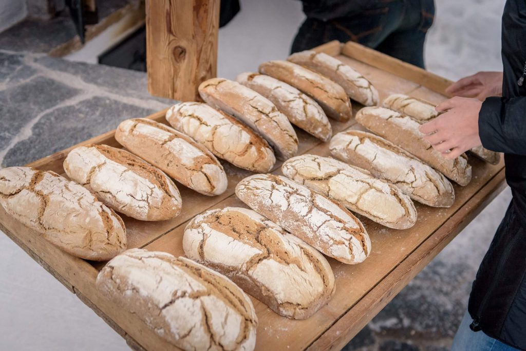 Frisch gebackenes Brot auf Holztablett im Schwabhof, ideal für den Urlaub am Bauernhof.